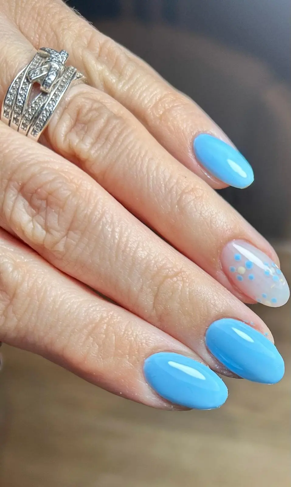 Nail art creativo en Noestyle Baeza: manicura azul cielo con diseño floral y lunares