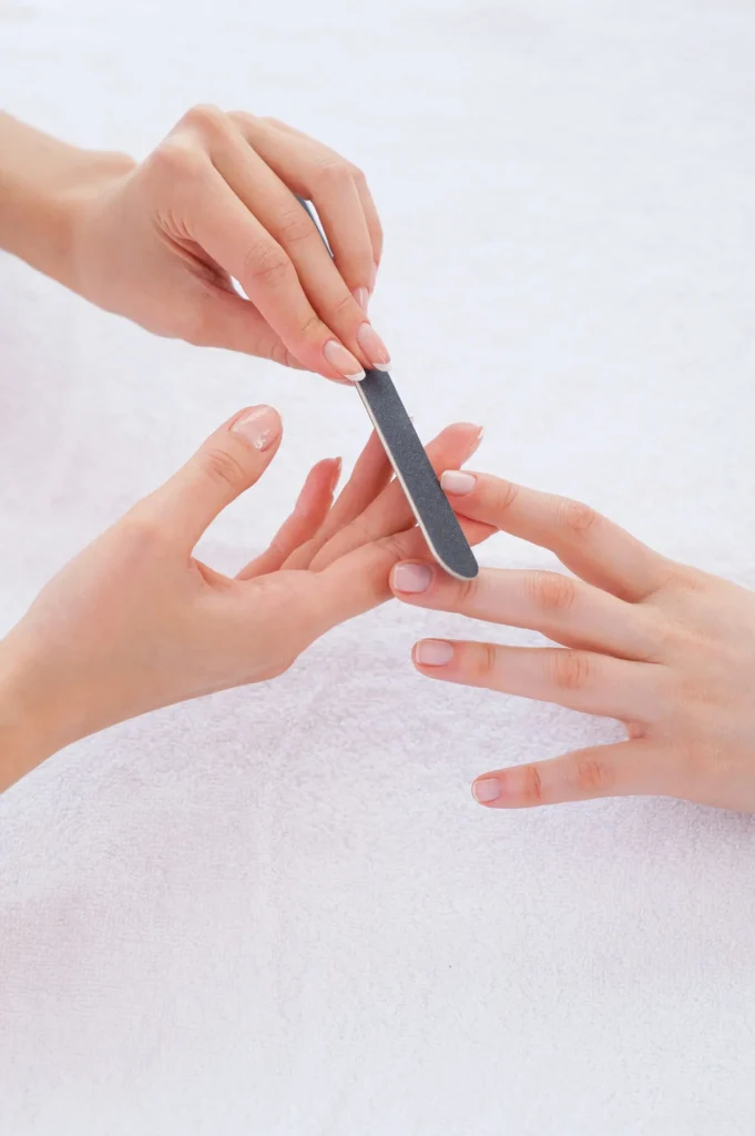 Manicura profesional en Noestyle Baeza: limado de uñas sobre toalla blanca